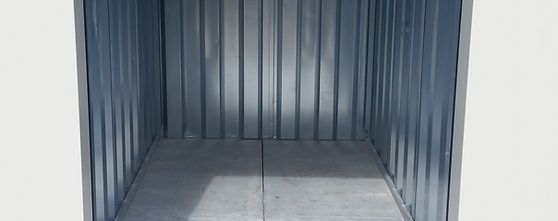 Empty storage container with a concrete floor and white walls, ideal for storing items securely.