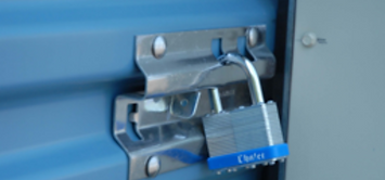 A blue padlock is locked to a blue door.
