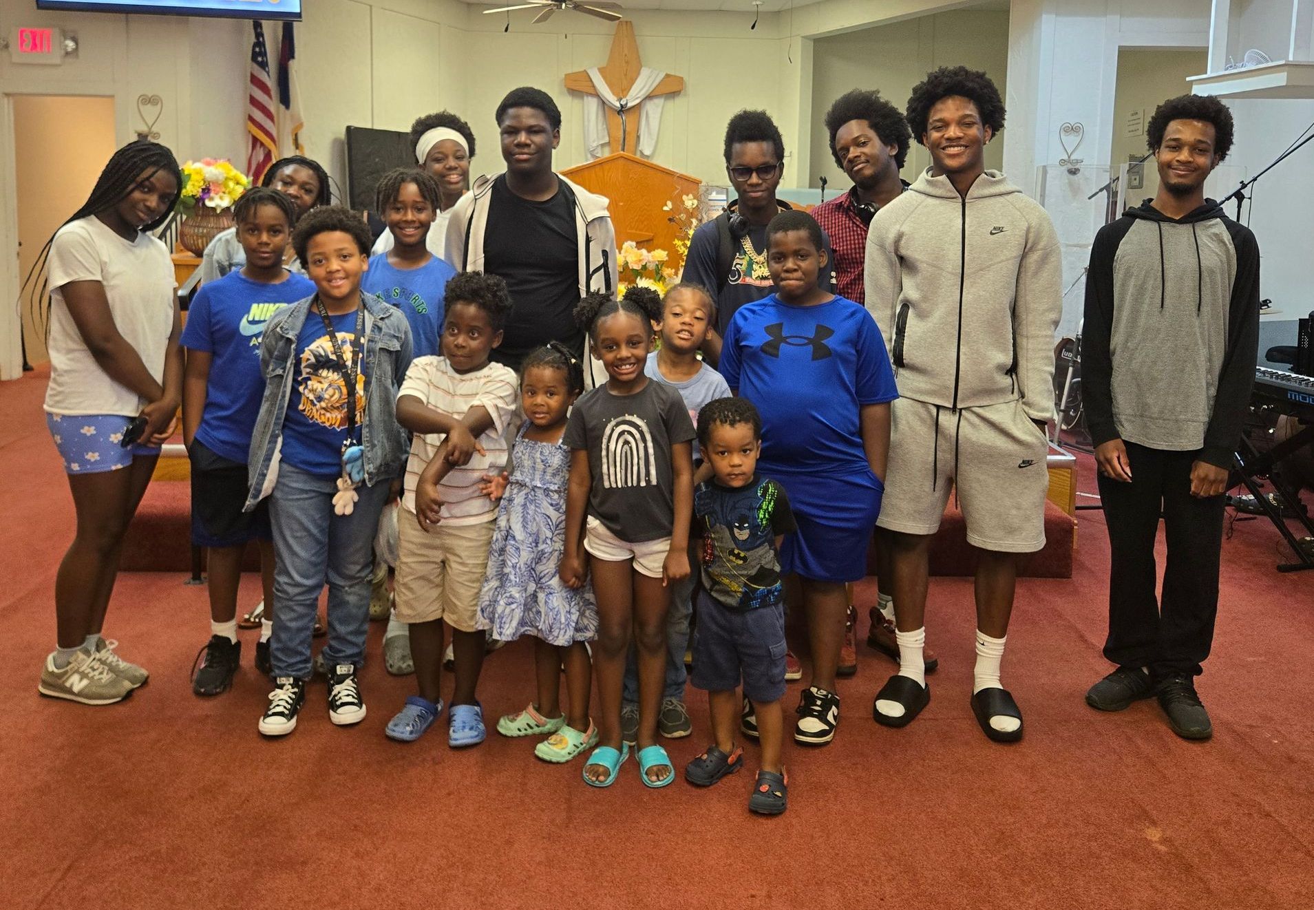 A group of young people are posing for a picture together and smiling.