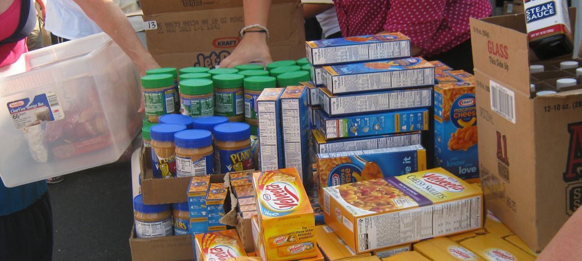 A person is standing in front of a pile of food.