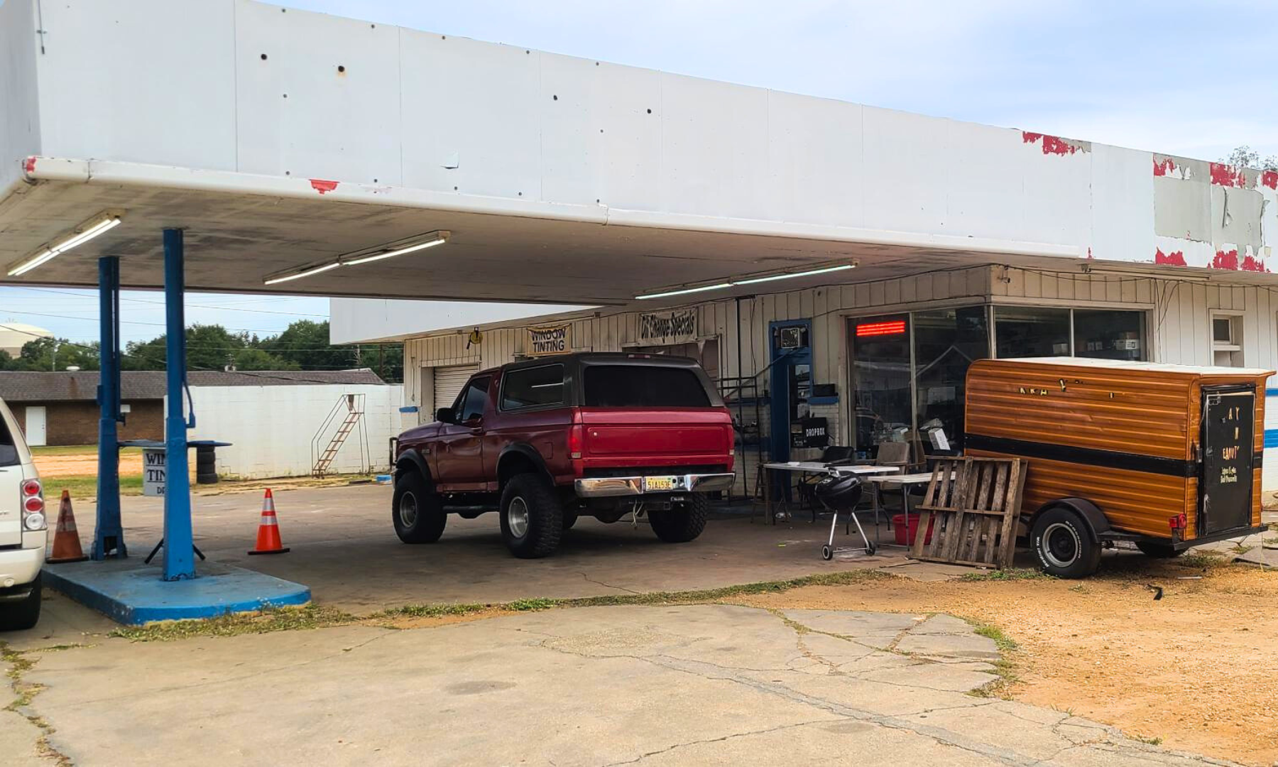 A red truck is parked in front of a gas station.