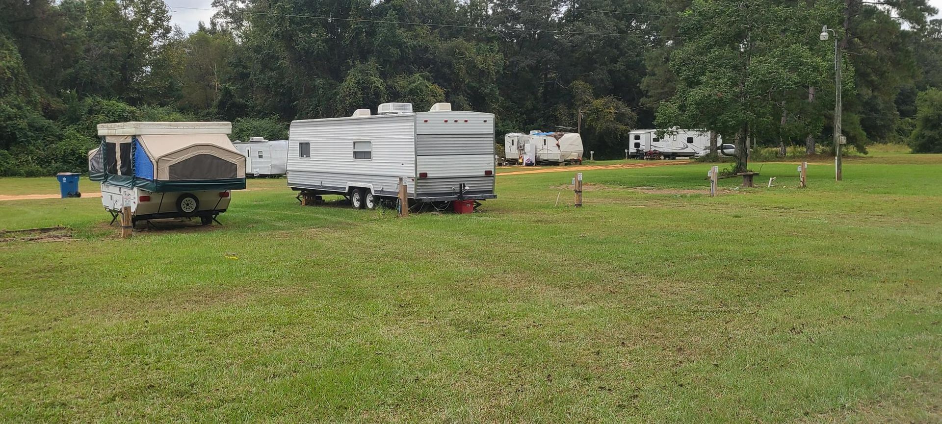 A large brick house is sitting in the middle of a lush green field.