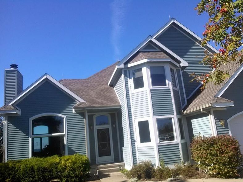 A large house with blue siding and a gray roof
