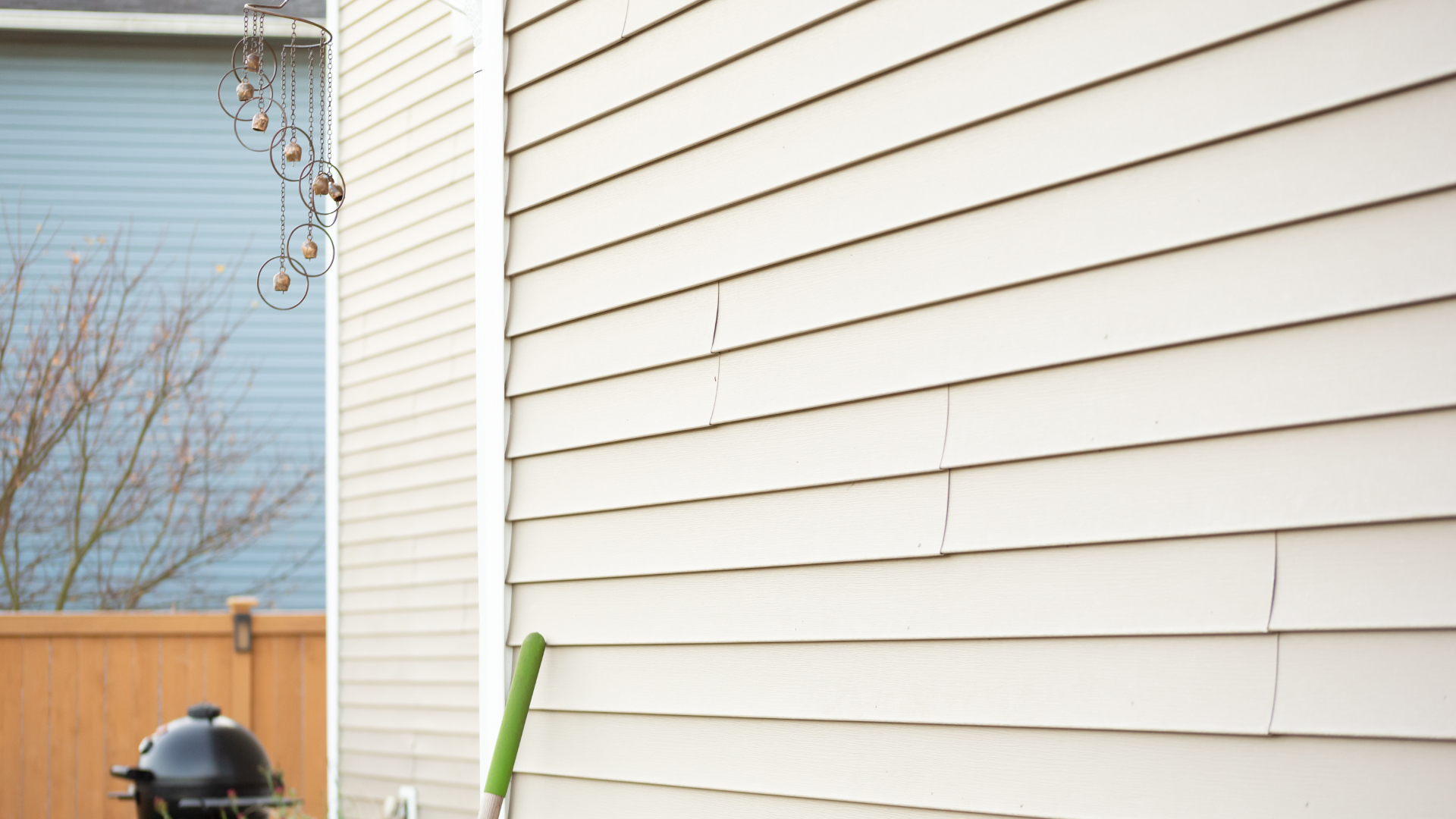 A white house with a black grill on the side of it.