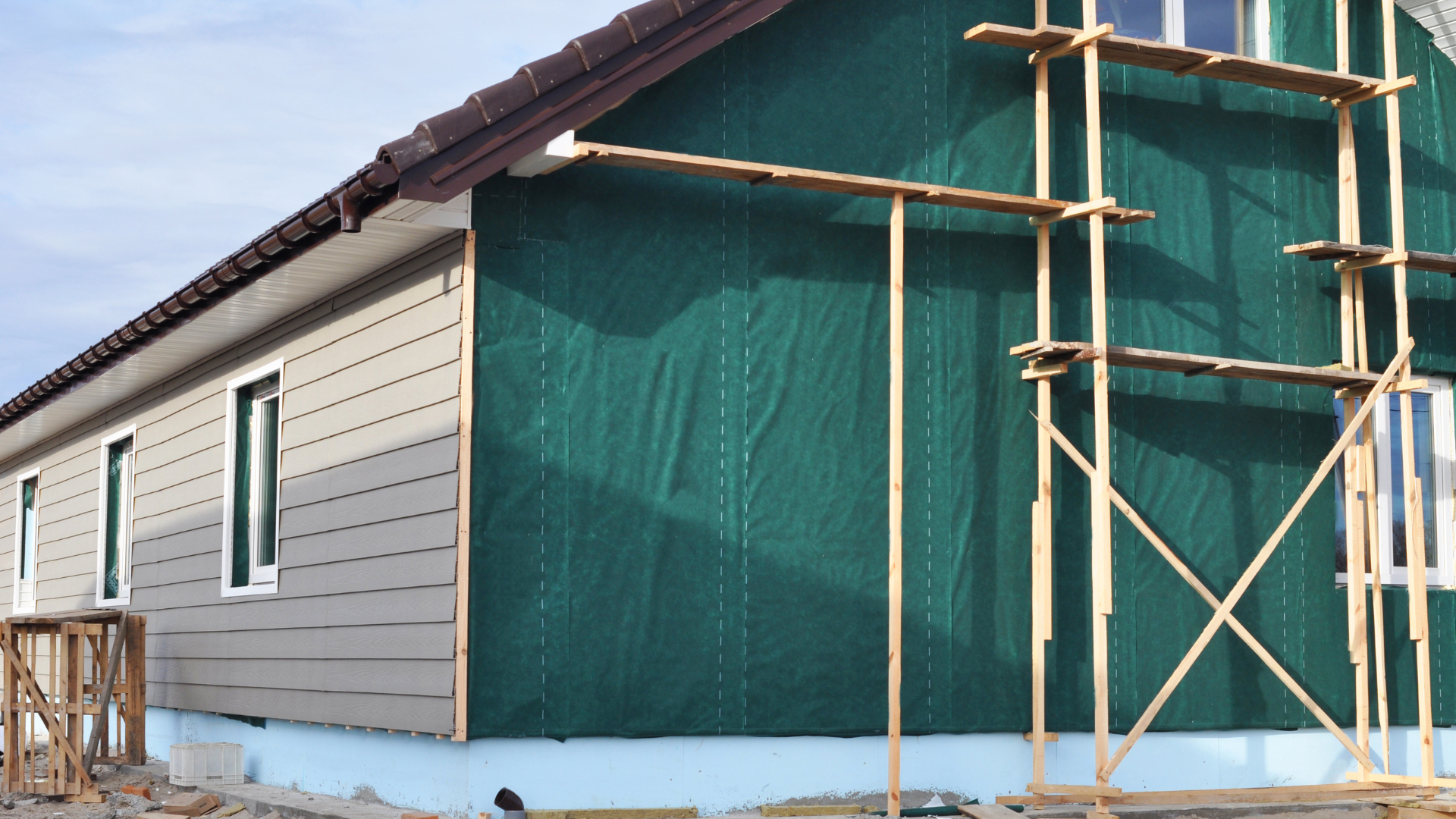 A house with a green siding is being built