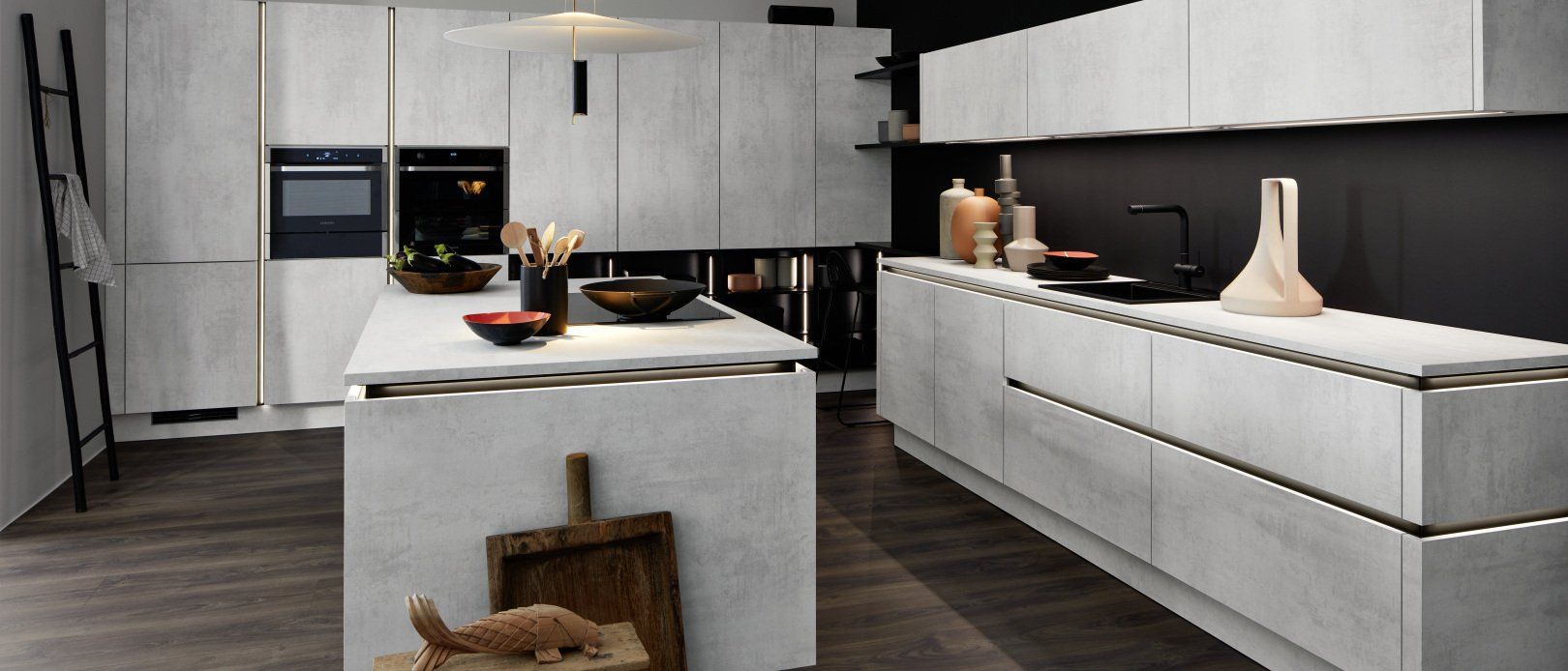 Une cuisine avec des armoires blanches et un grand îlot au milieu.