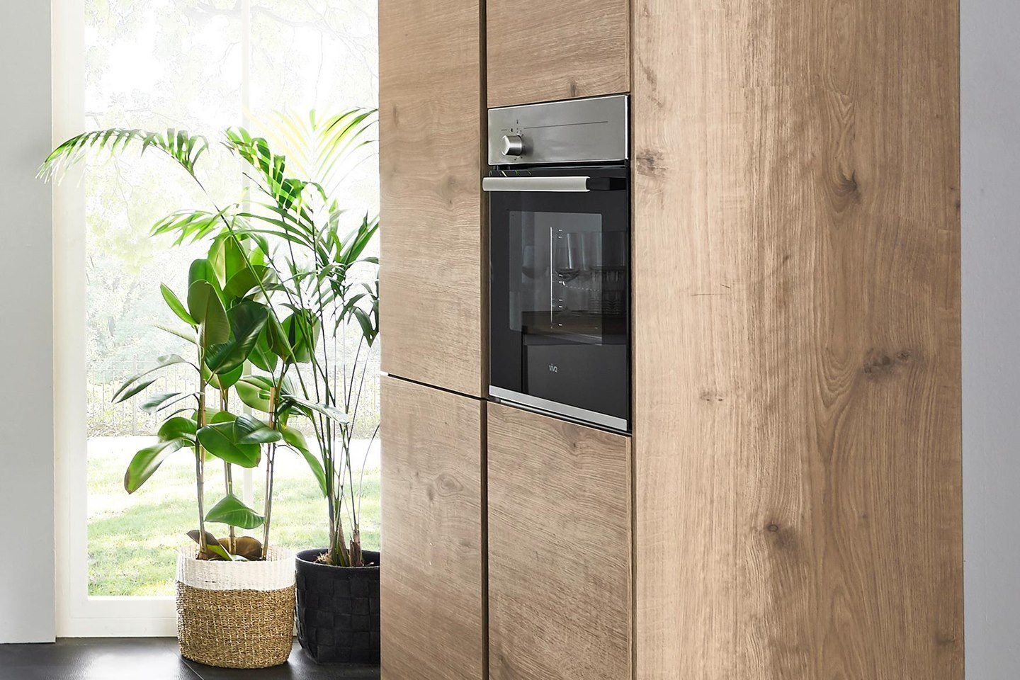 Une cuisine avec des armoires en bois et un four en acier inoxydable.