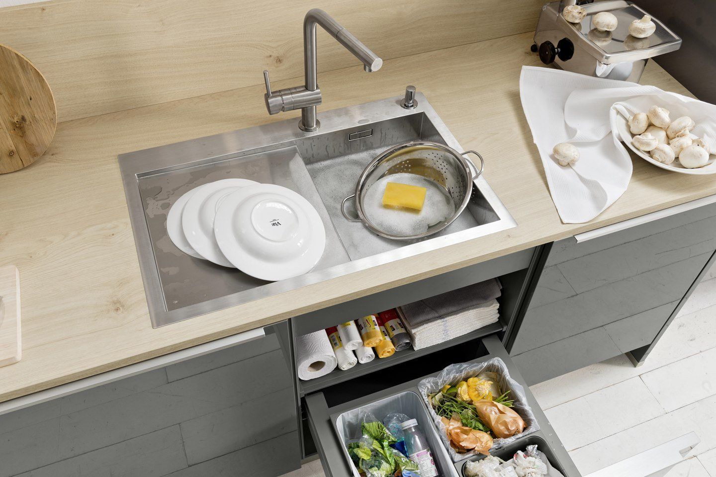 Un évier de cuisine avec des assiettes et une casserole dedans