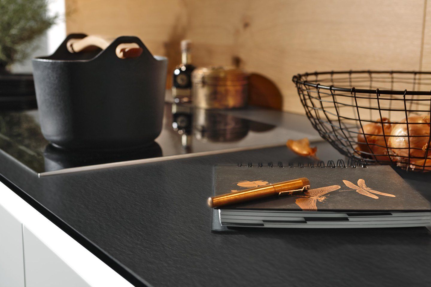 Un comptoir de cuisine avec un panier d'oignons et un cahier dessus