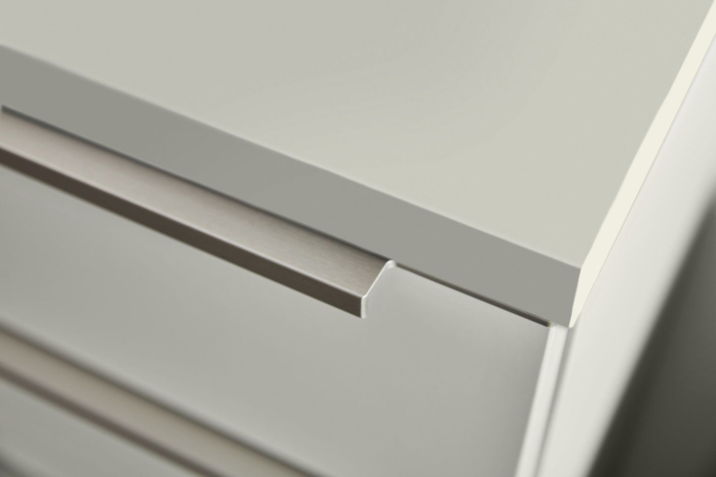 Un gros plan d'une commode blanche avec une poignée en métal.