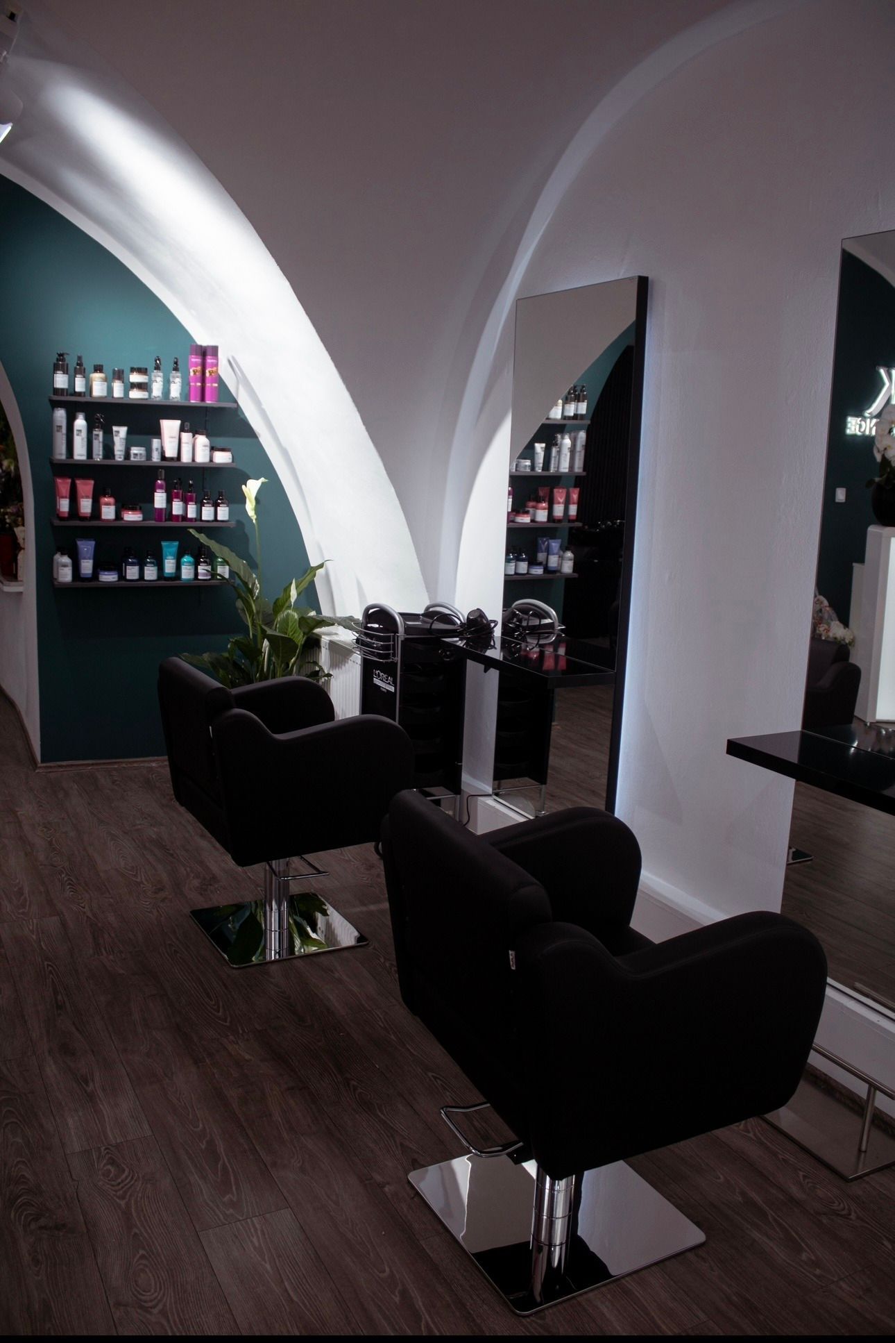 Ein Friseursalon mit zwei Stühlen und einem Spiegel