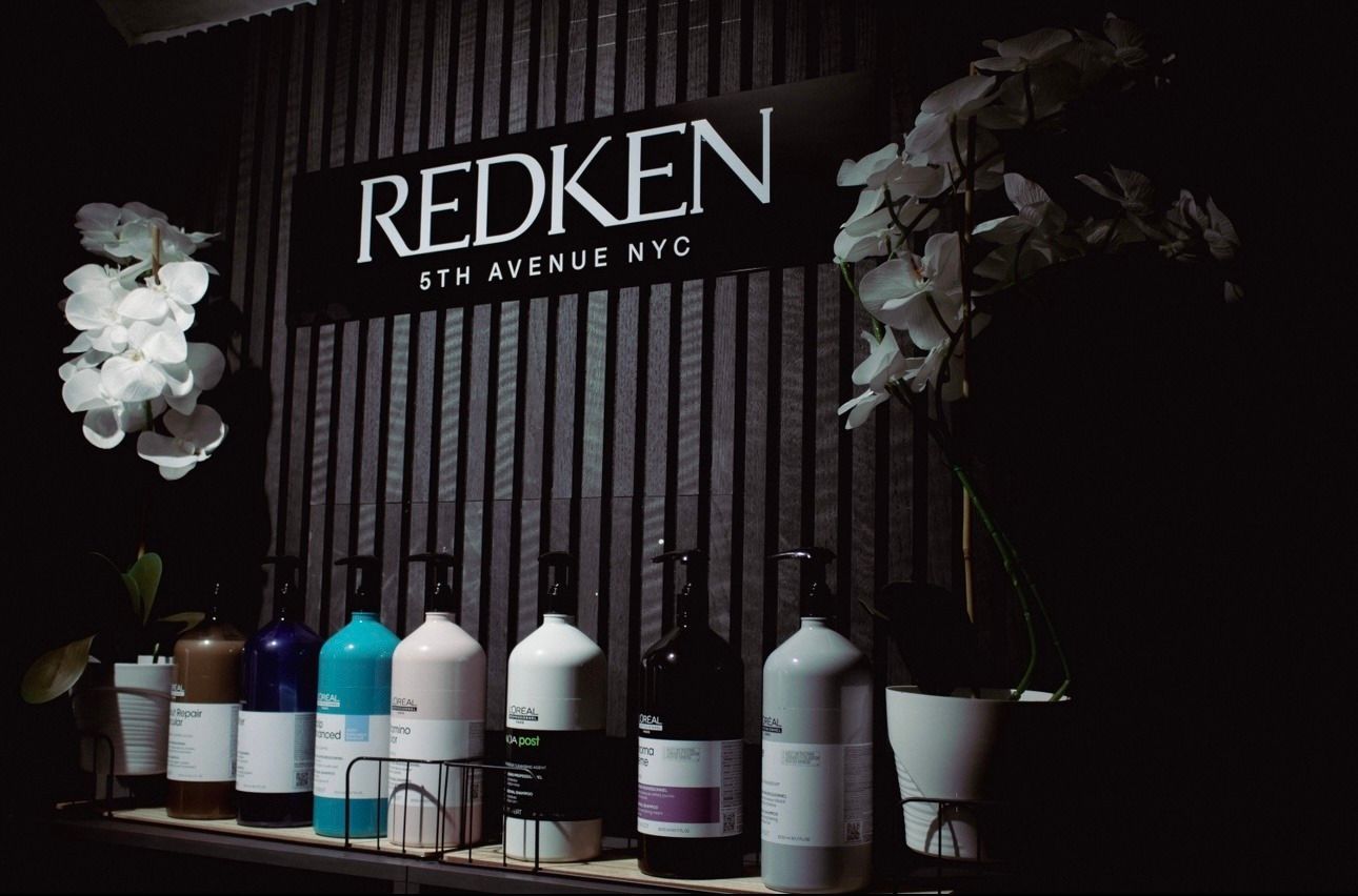 Ein Regal mit Flaschen mit Haarprodukten von Redken darauf