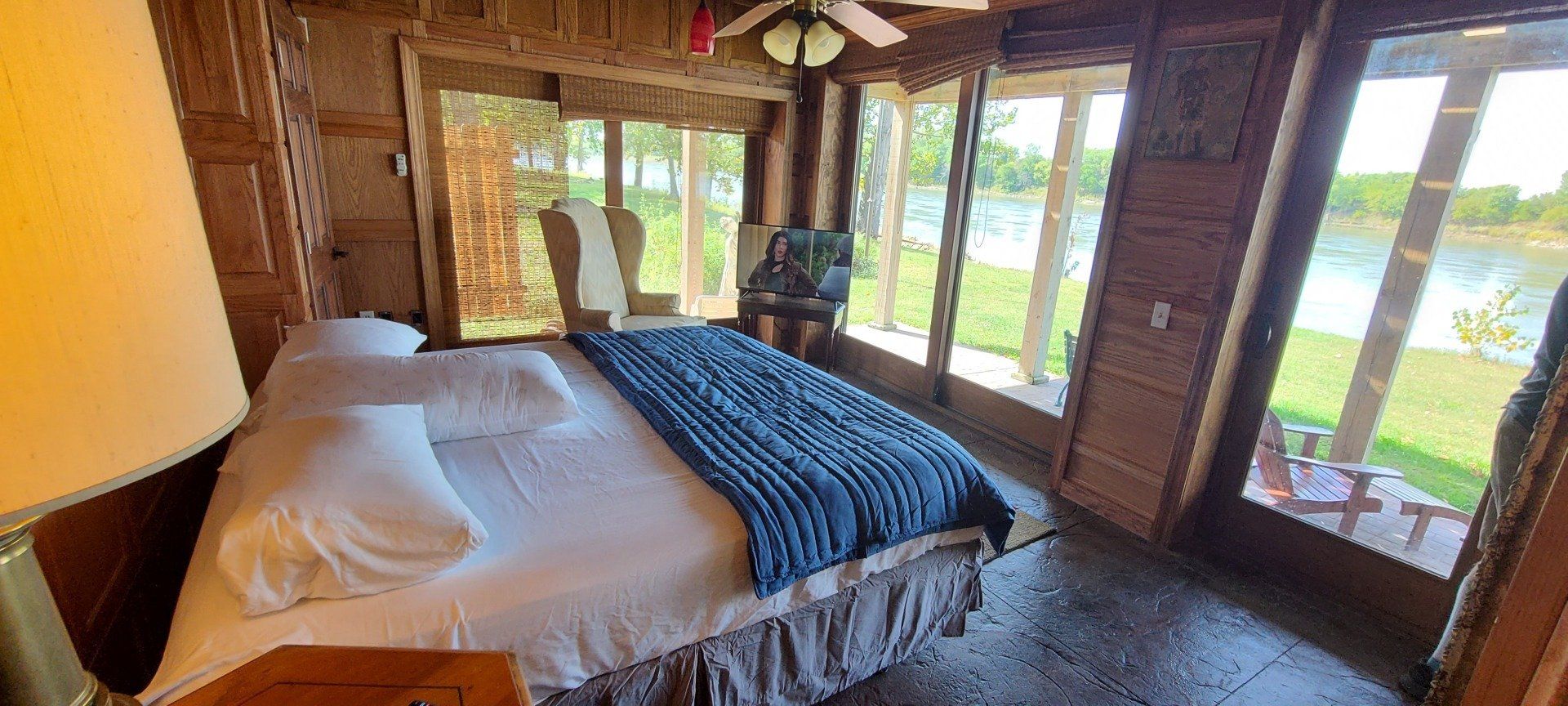 A bedroom with a king size bed and a ceiling fan.