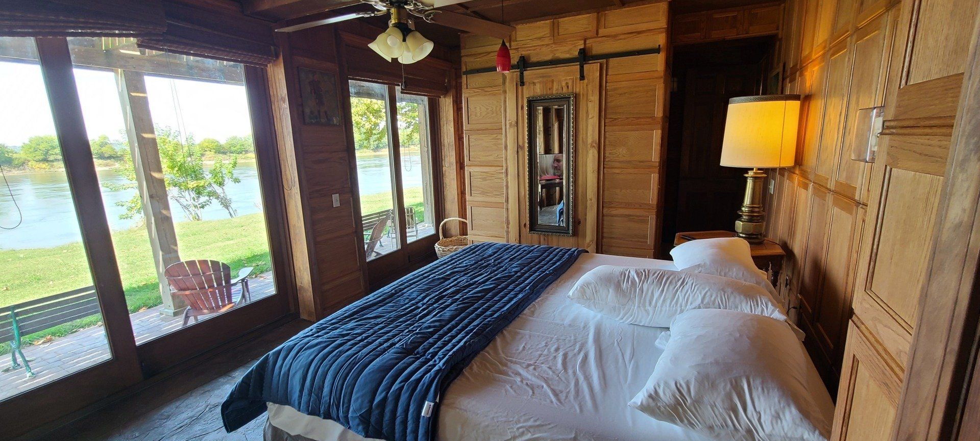 A bedroom in a log cabin with a large bed and lots of windows.