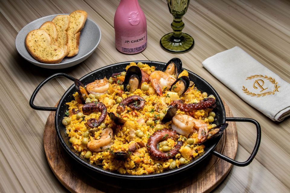 Paella con camarones, pulpo y mejillones servida en sartén, una excelente opción donde comer en coveñas en Hotel Poblado