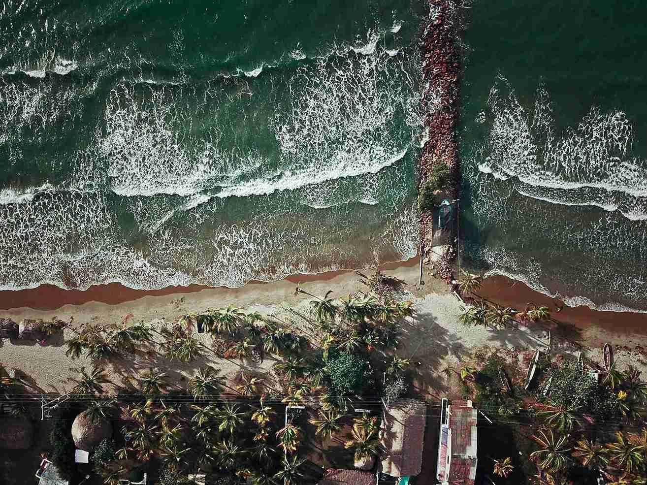Vista aérea de la playa en Islas de San Bernardo, con muelle, palmeras y mar, plan para hacer desde Coveñas.