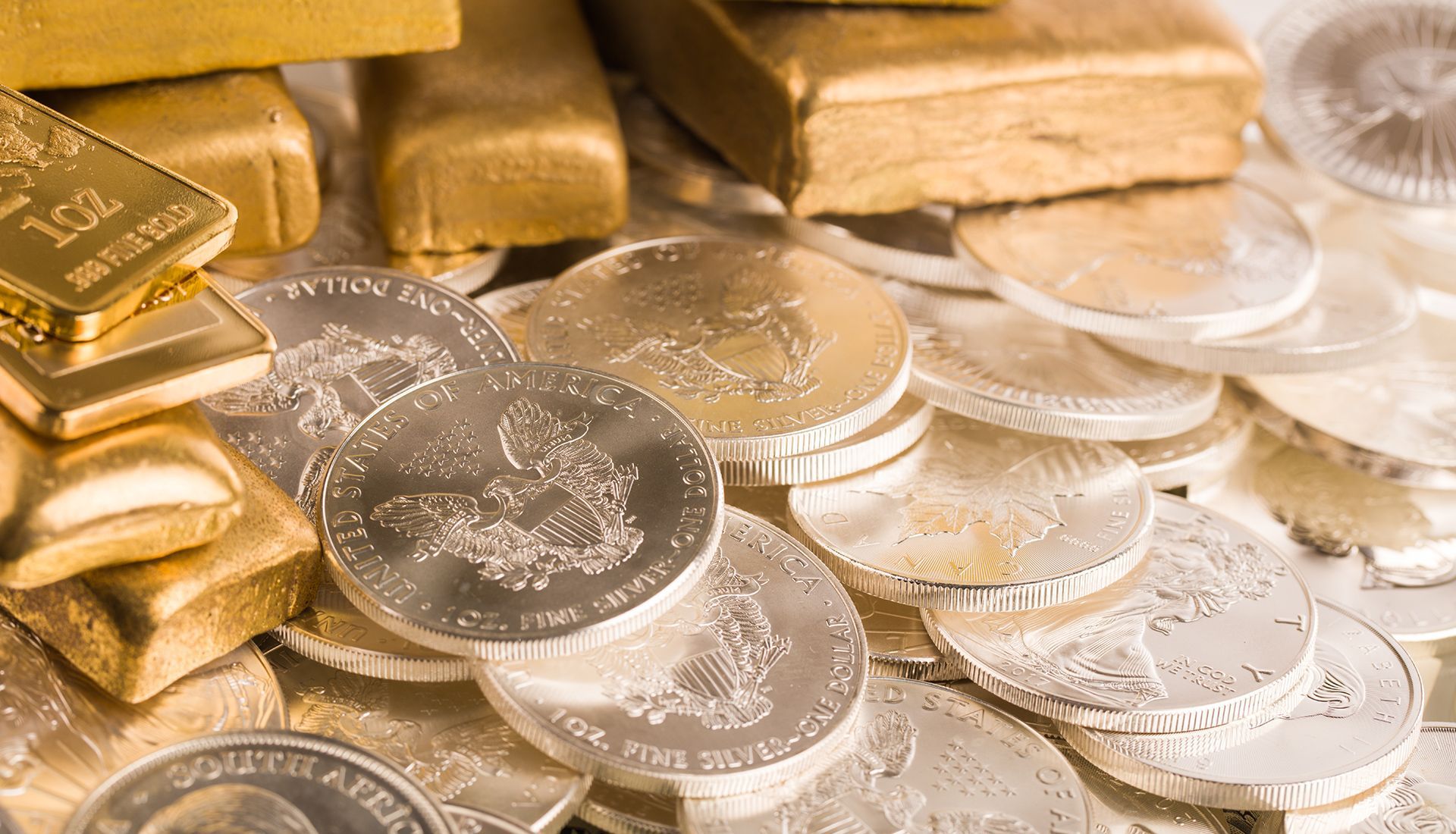 Gold bars and silver coins, a collection of precious metals.
