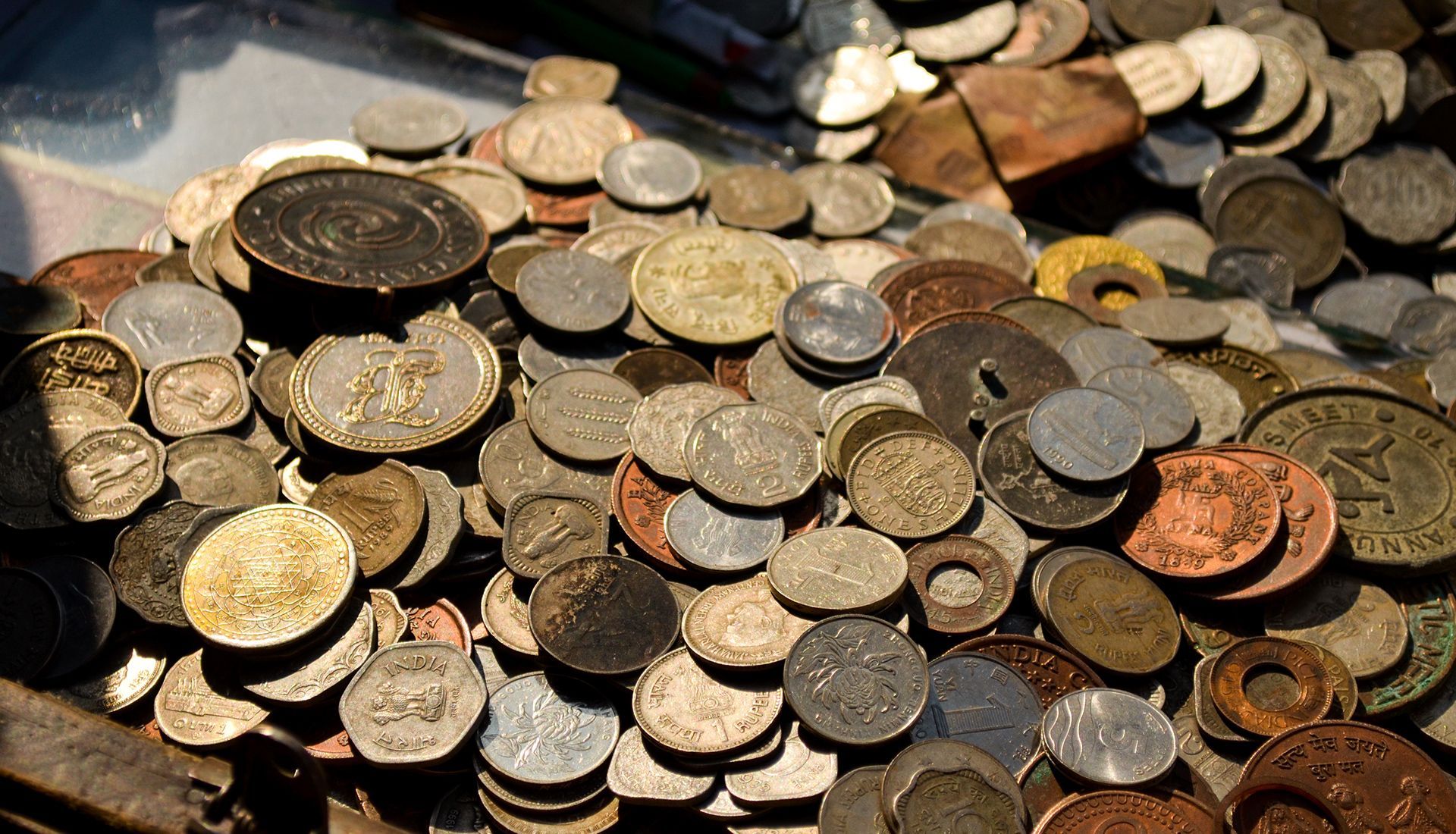 Pile of assorted old coins, varying sizes and metals.