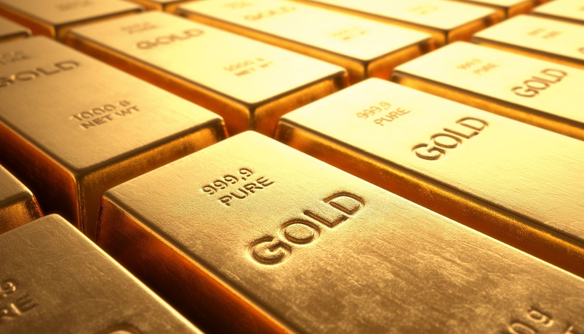Gold bars stacked in rows, metallic and shiny with imprinted text.