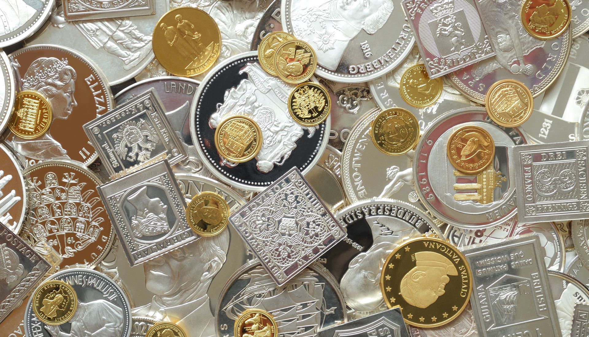 Scattered silver and gold coins, some square, some round, with various embossed designs.