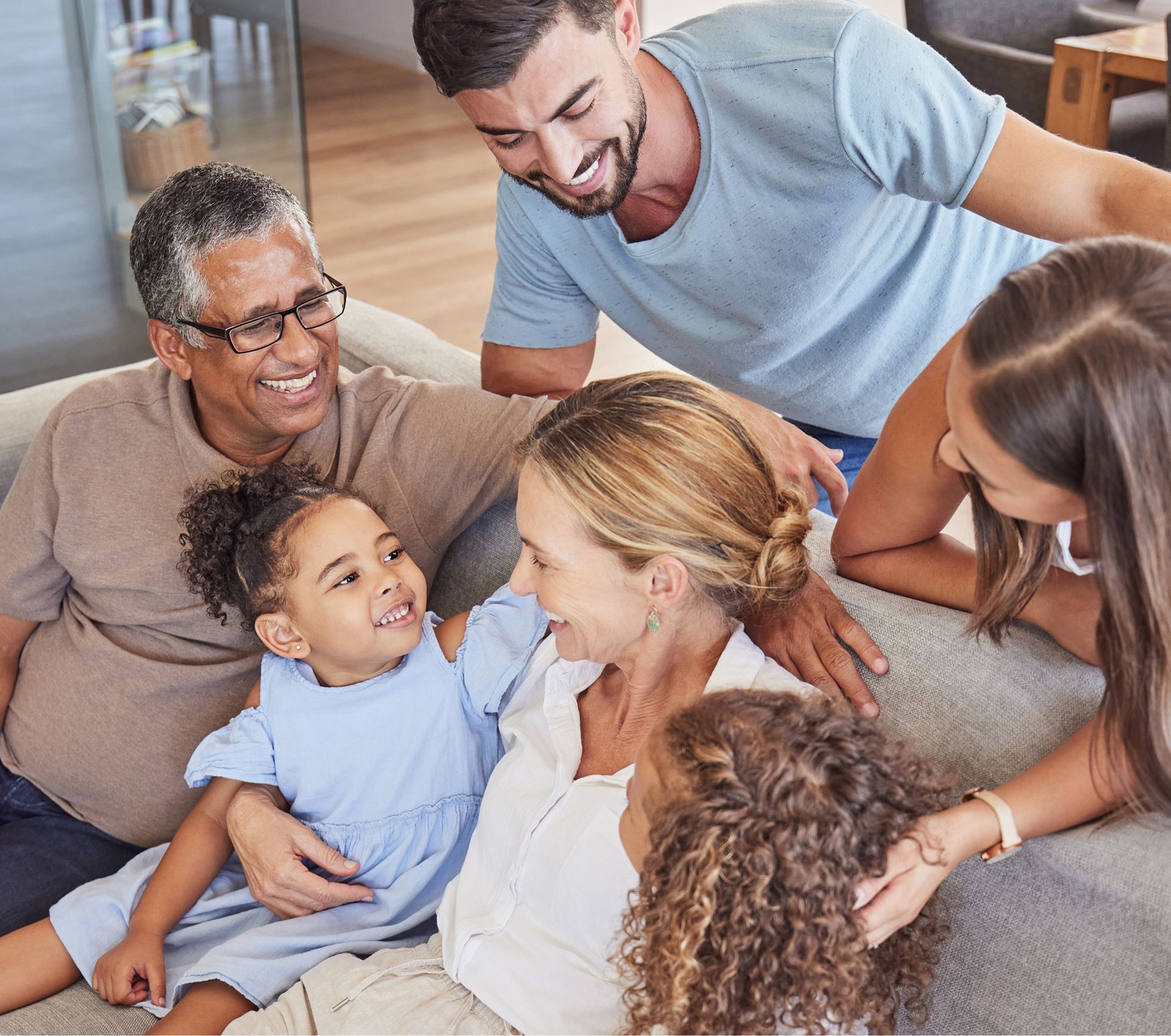 A group of people are sitting on a couch talking to each other.