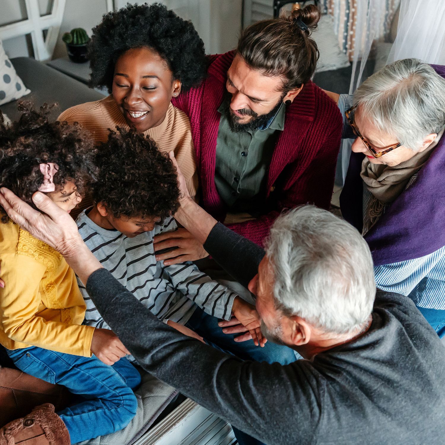 A group of people are sitting on a couch talking to each other.