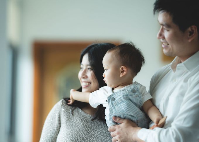 A man and a woman are holding a baby in their arms.
