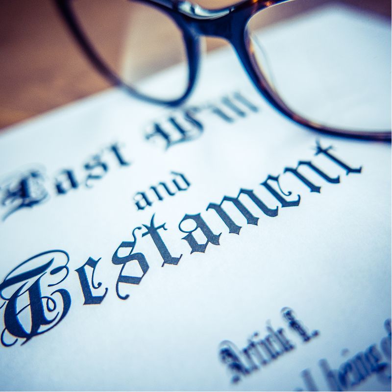 A pair of glasses rests on top of a last will and testament