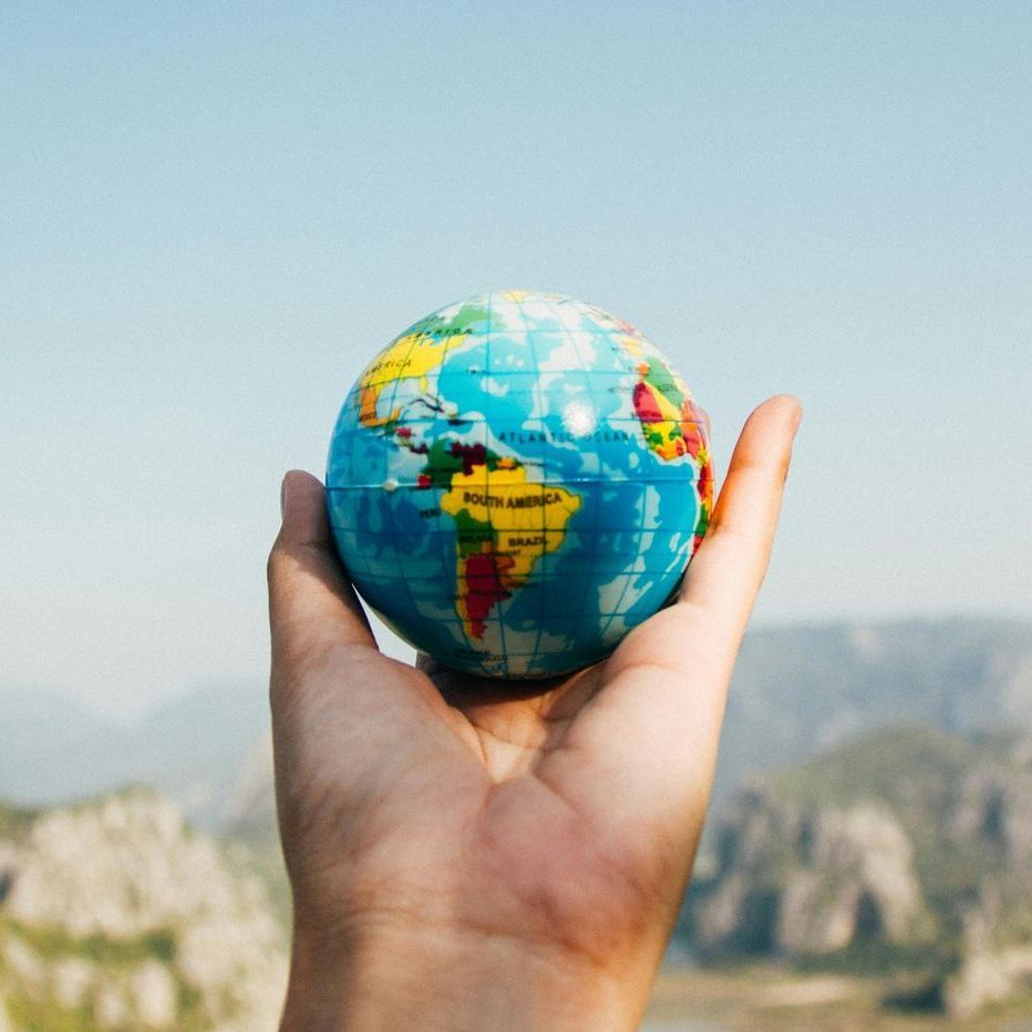 A person is holding a small globe in their hand