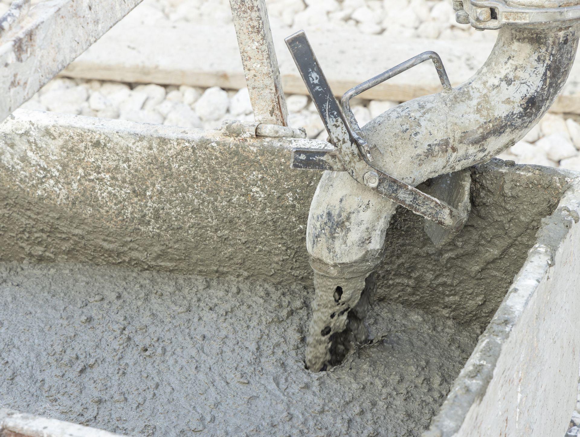Pouring fresh ready mixed concrete from mixer into a wheelbarrow during for construction. Pouring fresh ready mixed concrete from mixer into a wheelbarrow during for construction.
