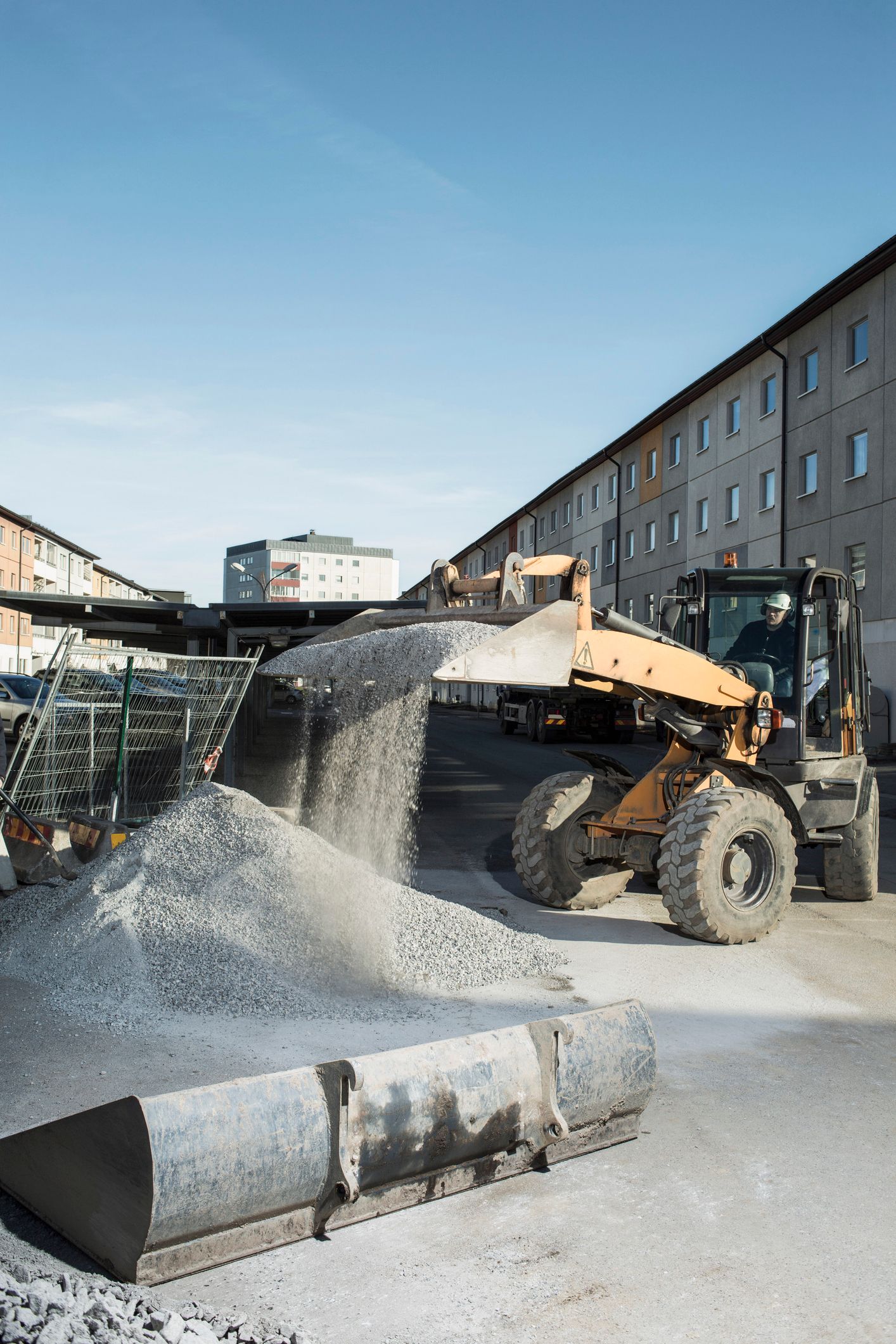 A construction worker loads sand into a truck for a concrete ready mix supplier delivery.