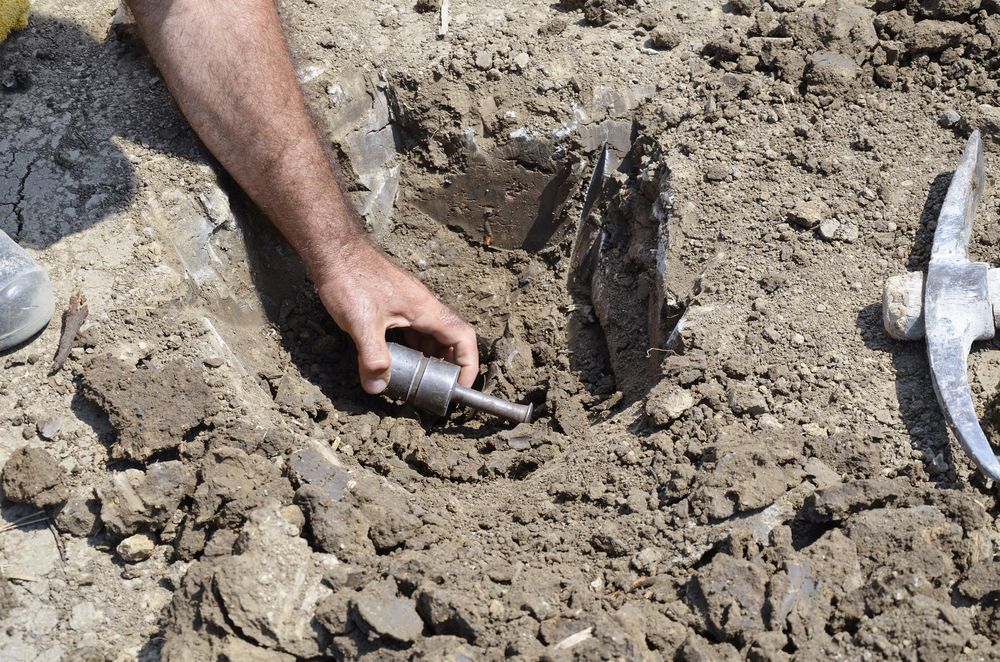 A Person Is Digging In The Dirt With A Shovel — PGI North QLD In Rosslea, QLD