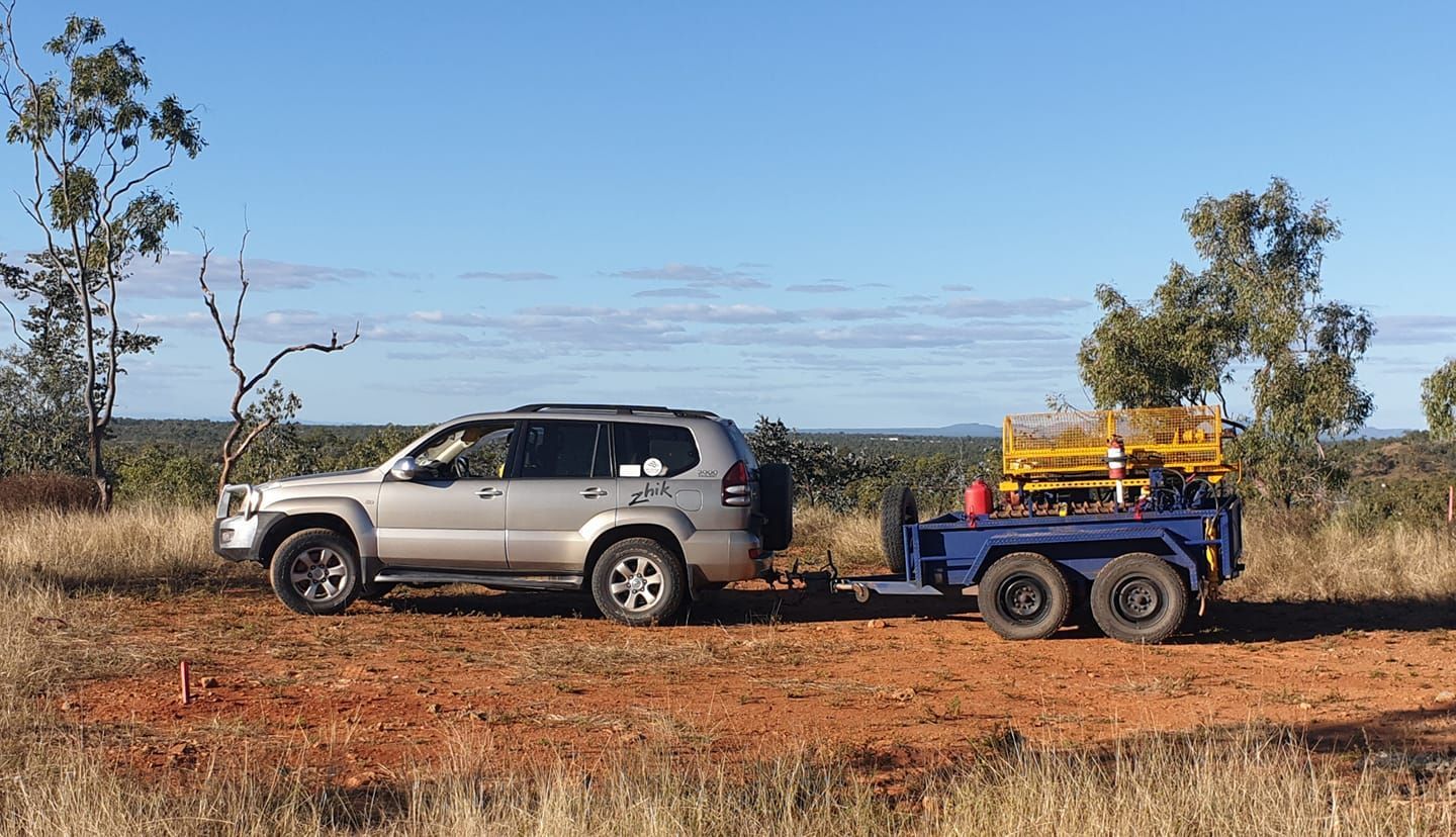 A Silver Suv Is Towing A Blue Trailer In A Field — PGI North QLD In Rosslea, QLD