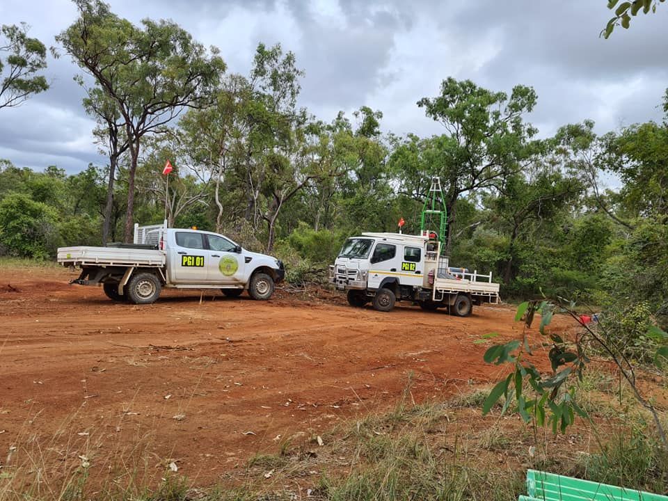 Two White Trucks Are Parked In A Dirt Field — PGI North QLD In Charters Towers, QLD