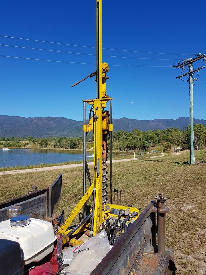 A Yellow Drill Is Sitting On The Back Of A Truck In A Field — PGI North QLD In Ayr, QLD