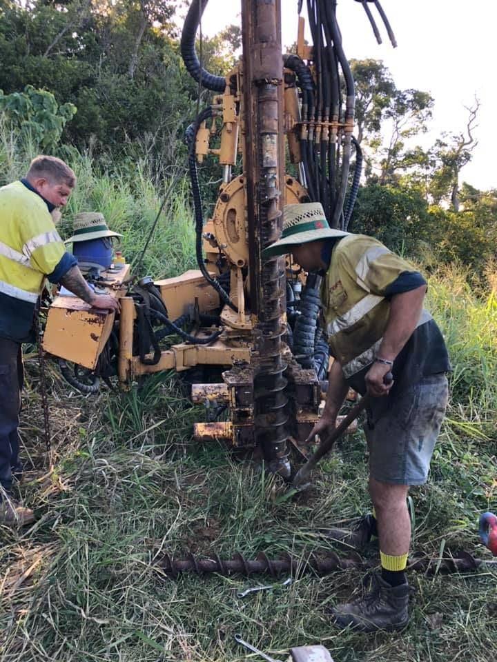 Two Men Are Working On A Machine In A Field — PGI North QLD In Ingham, QLD