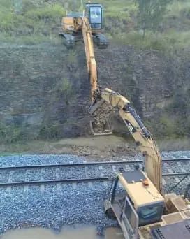A Yellow Excavator Is Working On A Train Track — PGI North QLD In Charters Towers, QLD