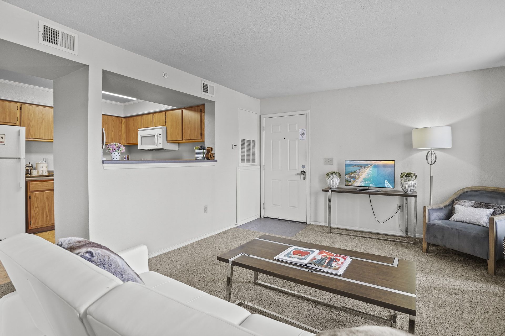 A living room with a white couch and a coffee table.