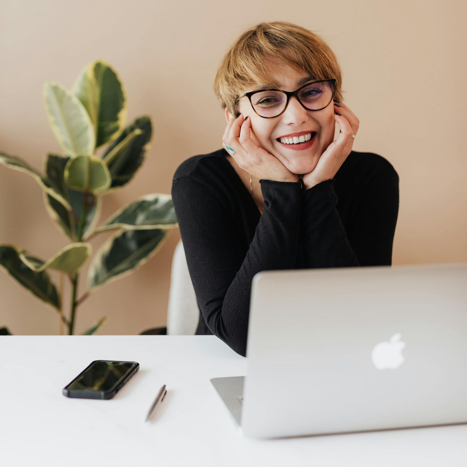 A woman is sitting at a desk with a laptop computer.
