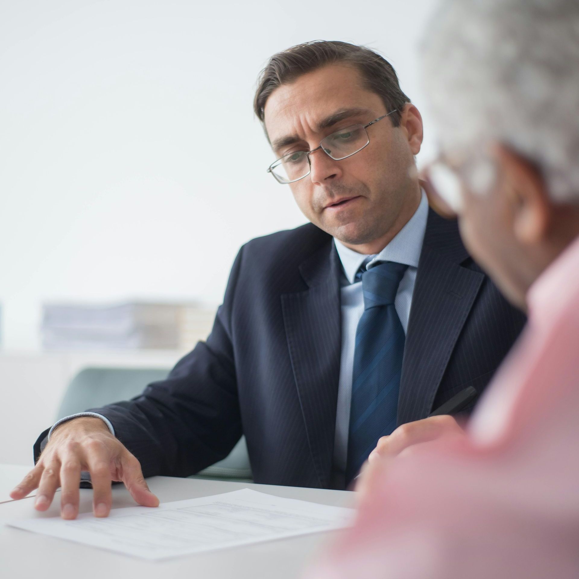 A man in a suit and tie is talking to another man