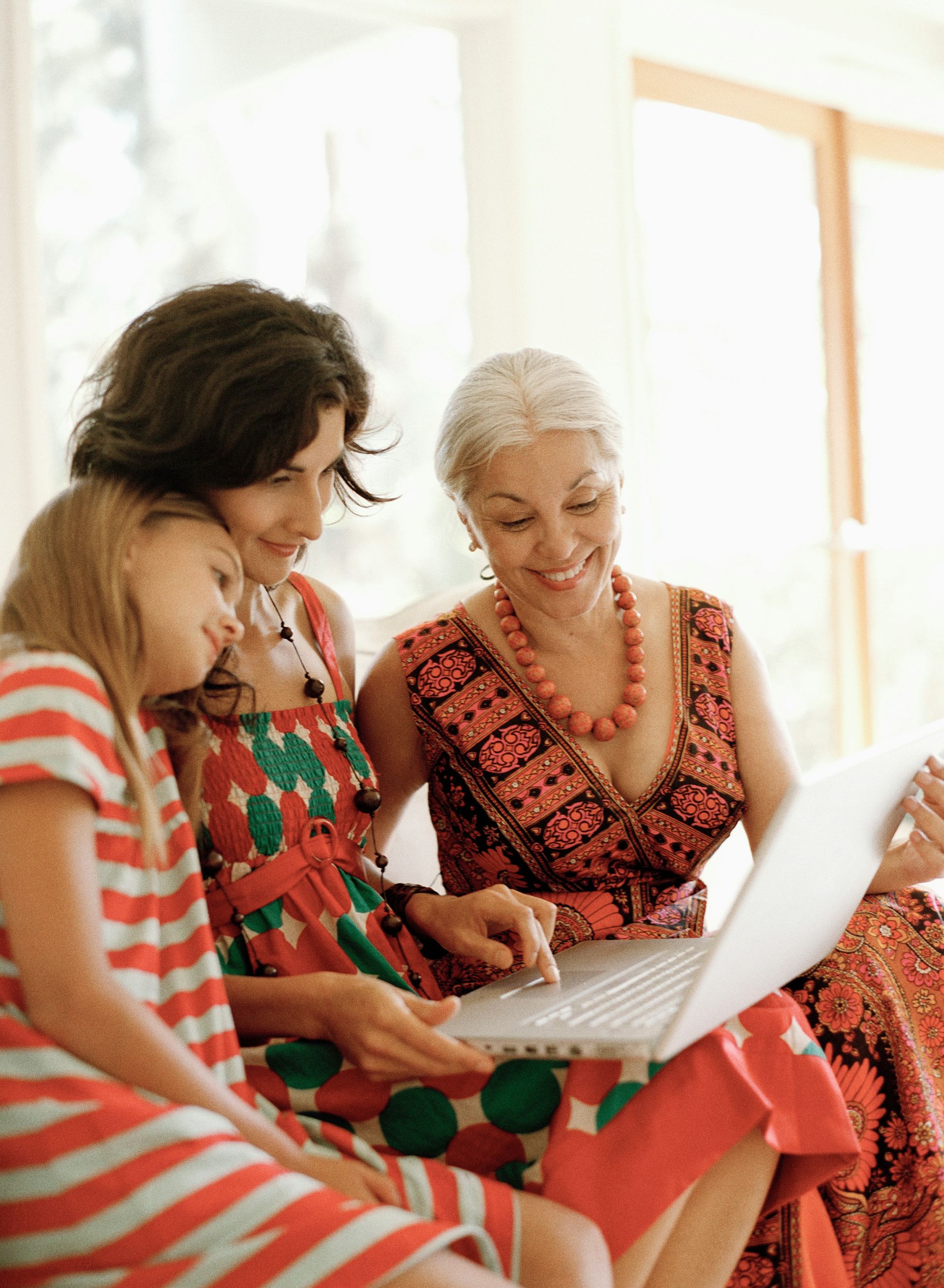 A family is sitting on a couch hugging each other.