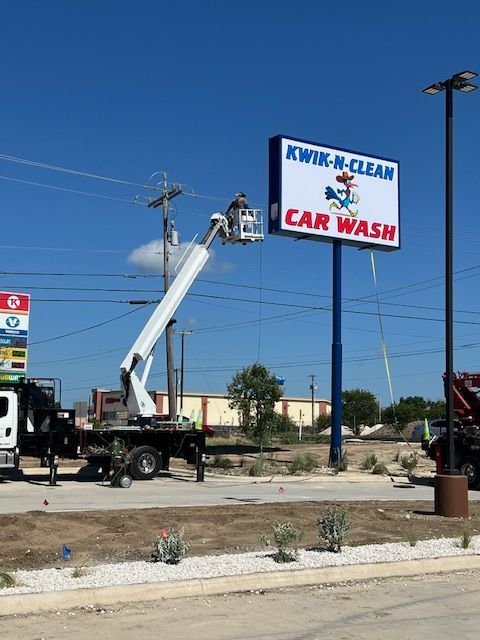 Building a carwash and installing a sign. Express car wash installation in San Antonio Texas for Kwik-n-Clean Car Wash with road runner logo