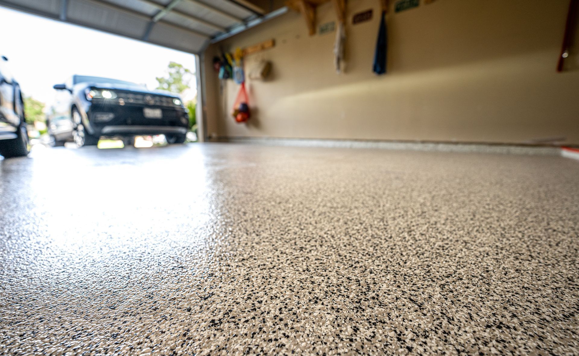 Vibrant epoxy garage floor showcasing a glossy, smooth surface with an abstract pattern in shades of black, brown and white