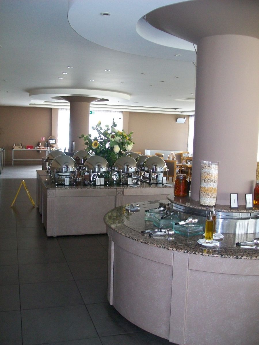 Buffet met warmhoudvitrines en serveergedeelte in de eetzaal van een hotel. Beige tinten.