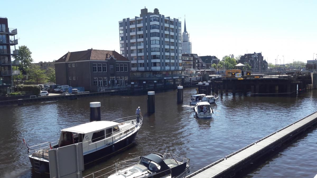 Boten op een kanaal met gebouwen op de achtergrond op een zonnige dag.