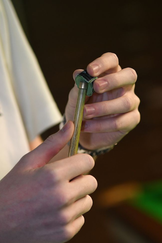 Persoon houdt een keu vast. Close-up toont handen die de zilveren schacht en zwarte onderkant vasthouden.