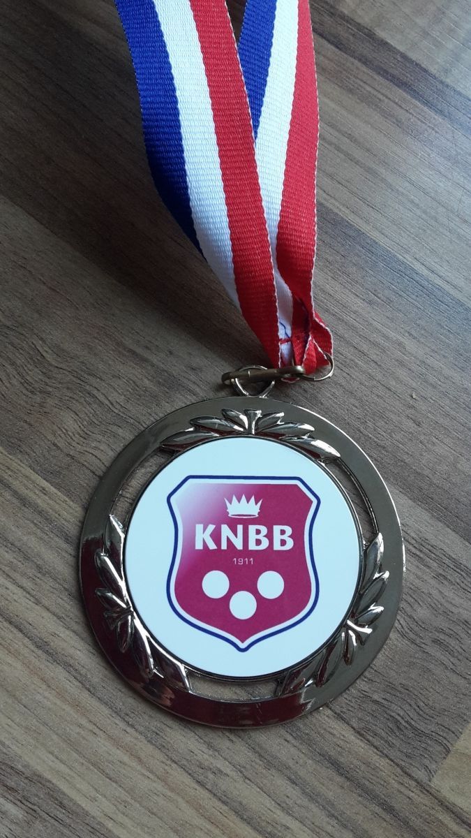 Gouden medaille met rood, wit en blauw lint; met een schild met 