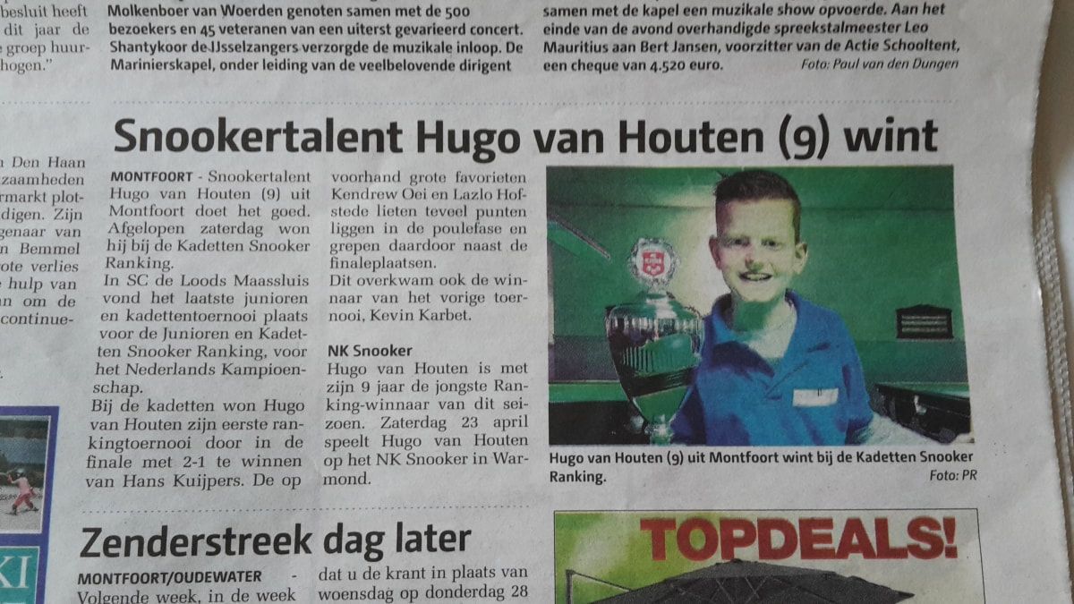 De negenjarige Hugo van Houten met een trofee na het winnen van een snookertoernooi. Hij draagt een bril en een blauw shirt.