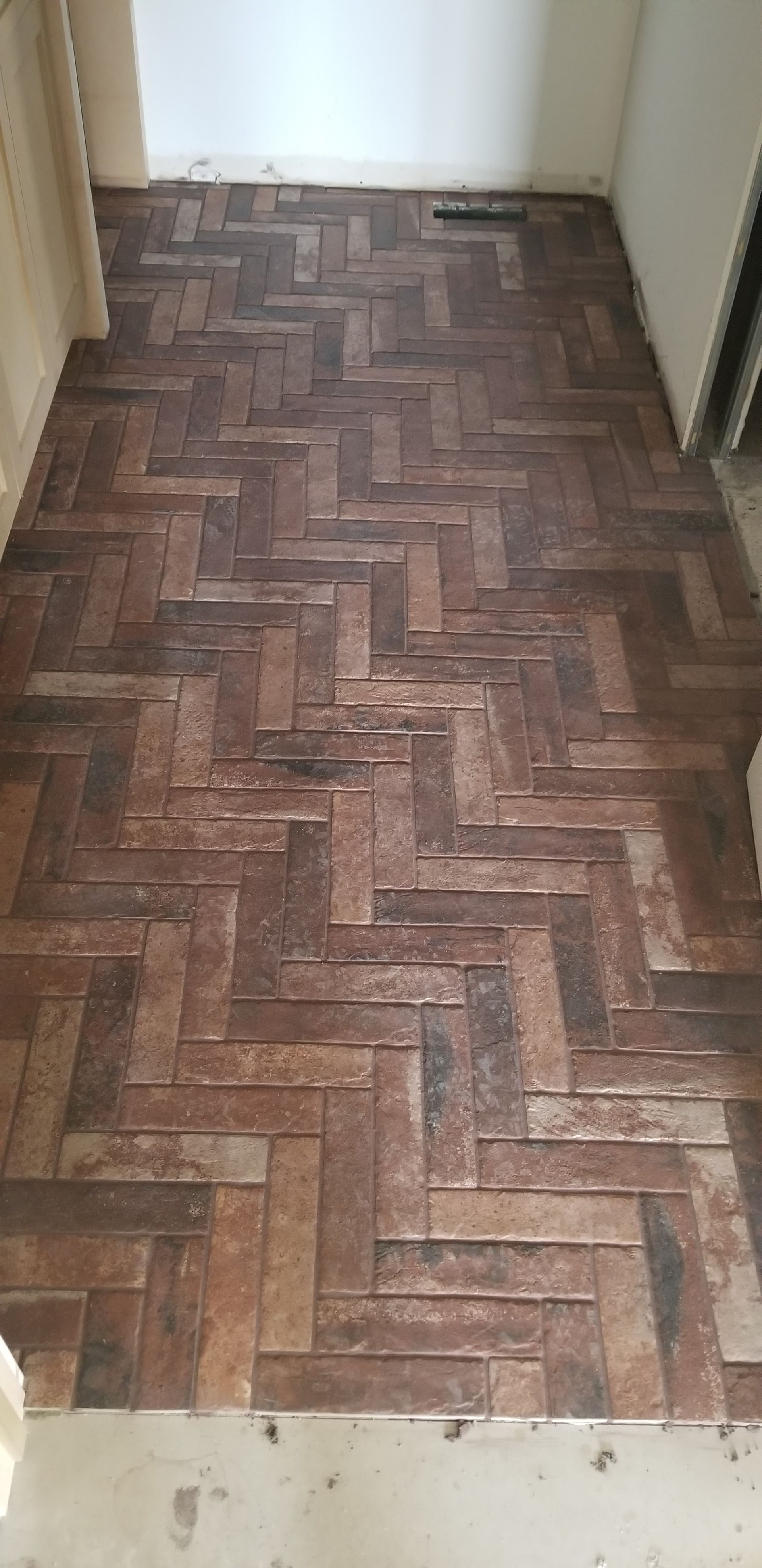 A brick floor in a room with a herringbone pattern.