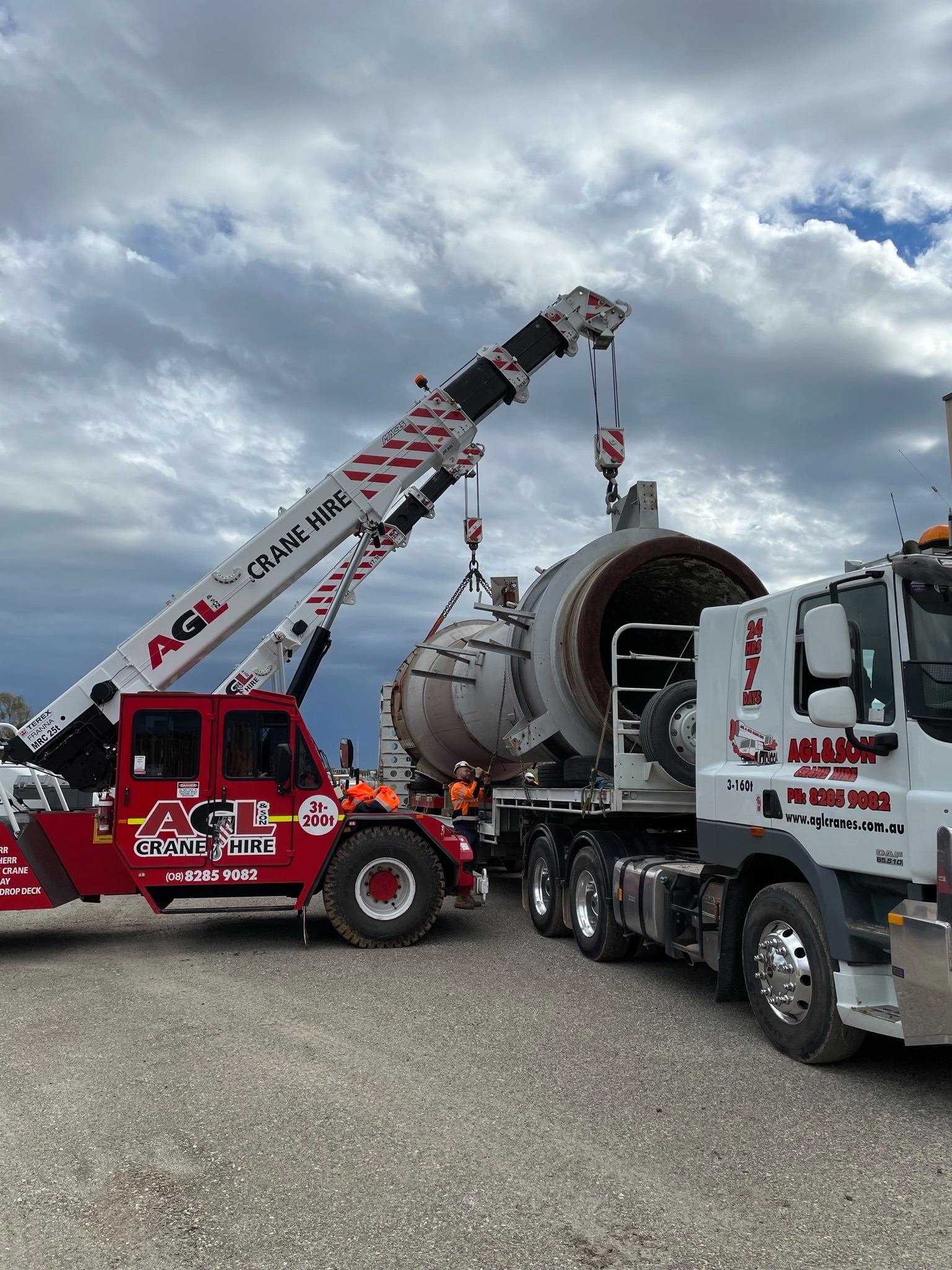 A crane is lifting a large object on top of a truck.